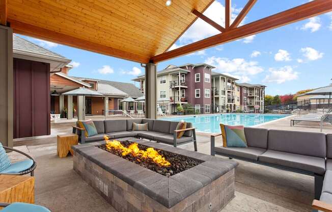 A patio with a fire pit and couches.