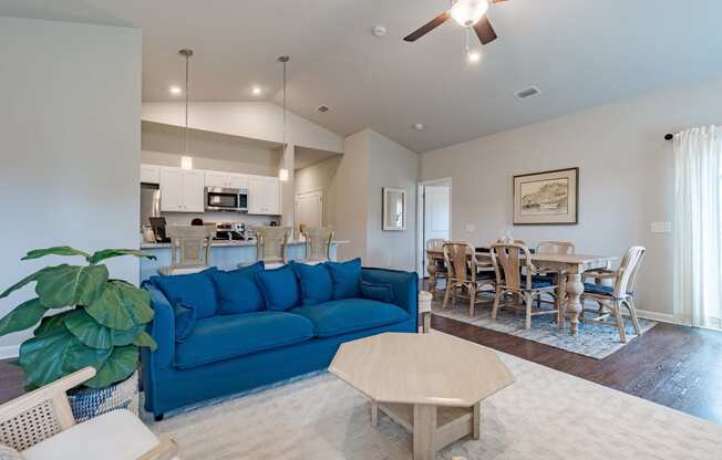 a living room with a blue couch and a dining room table