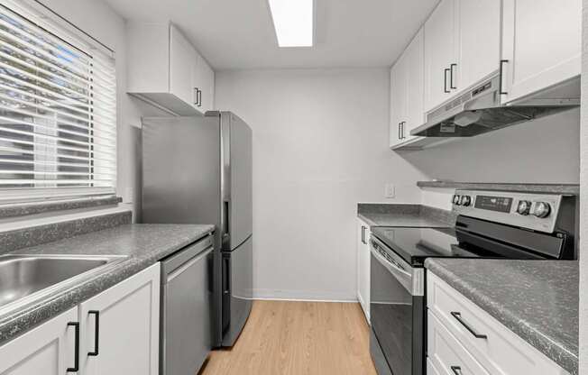 A modern kitchen with stainless steel appliances and white cabinets.