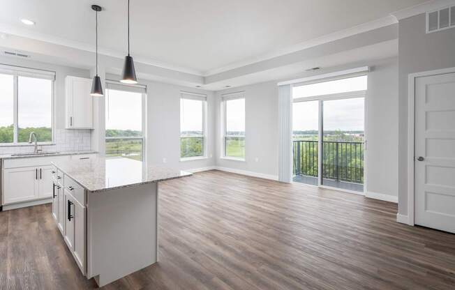 A kitchen with white cabinets and a wooden floor.