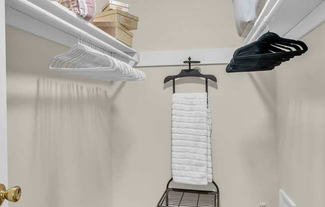 A small room with a hanging clothes rack and a carpeted floor.