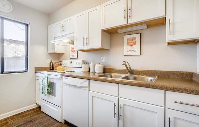 A kitchen with white appliances and cabinets.