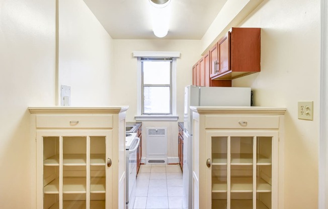 kitchen with wood cabinetry, electric range, refrigerator, and window at eddystone apartments in washington dc