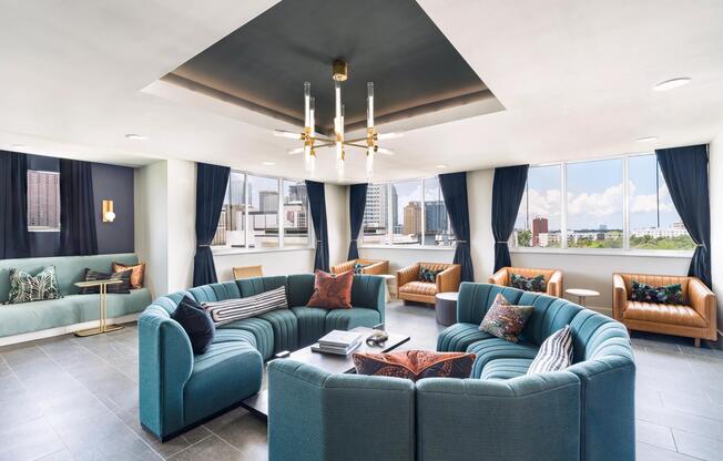 The resident lounge features comfortable seating, flexible gathering spaces, and expansive city views designed for socializing, working, or relaxing.