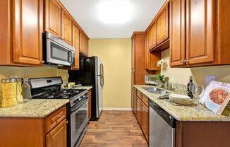 A kitchen with wooden cabinets and a granite countertop.