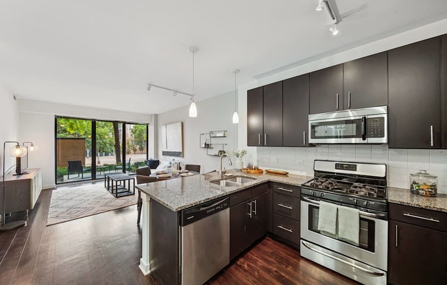 A modern kitchen with dark wood cabinets and stainless steel appliances.