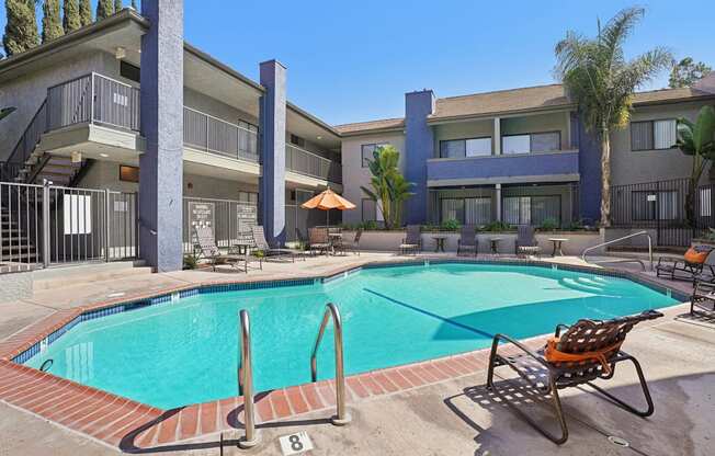 A pool with a chair and a building in the background.