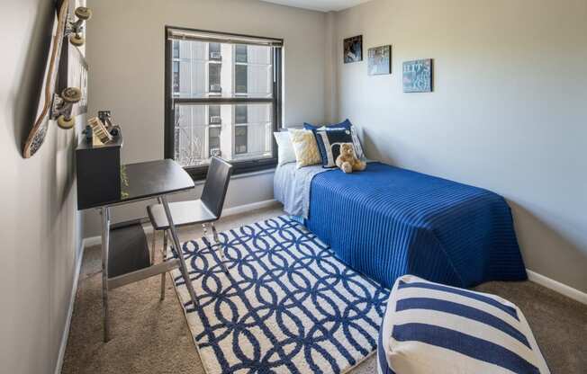 Bedroom photo with large window and blue furnishings