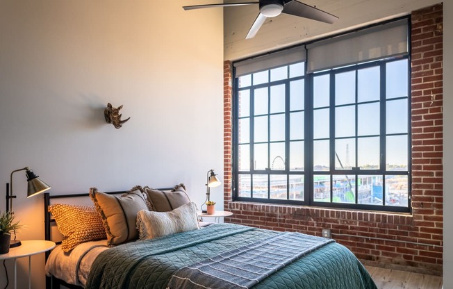 a bedroom with a large bed and a large window at The 22 Apartments, St. Louis, MO 63103