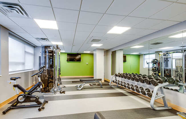 A gym with a variety of equipment including weights and cardio machines.
