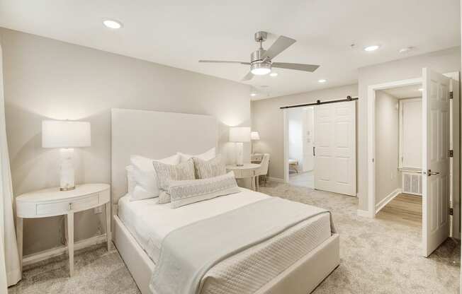 a white bedroom with a large bed and a ceiling fan at The Azul Apartment Homes, Oxford, Mississippi