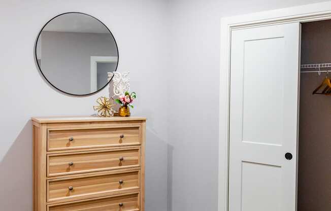 a bedroom with a dresser and mirror