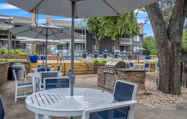 a patio with tables and chairs and umbrellas in front of a building