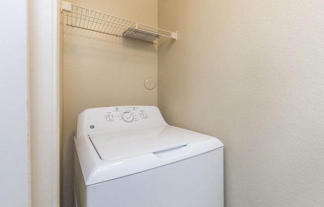 Laundry closet with full-size washer/dryer and shelf for extra storageÂ 