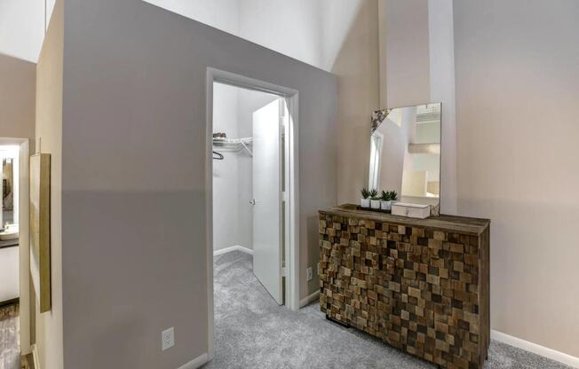 a room with a dresser with a mirror and a closet