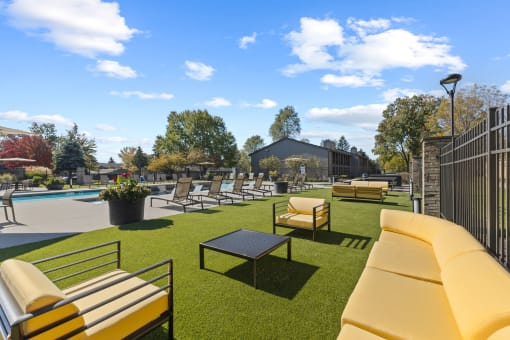 a patio with a couch and chairs and a pool