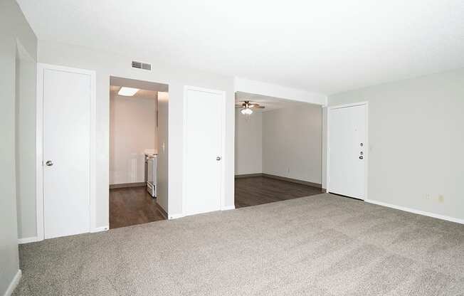 A large, empty room with carpeted floors and white walls.