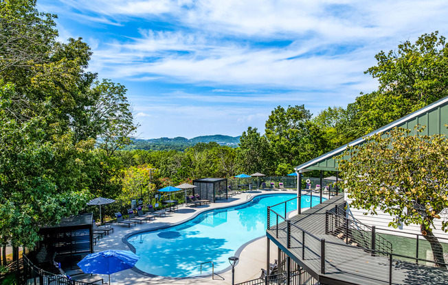 A large outdoor swimming pool surrounded by trees.