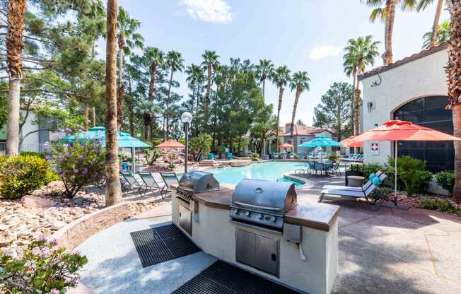 a patio with a grill and a swimming pool with umbrellas