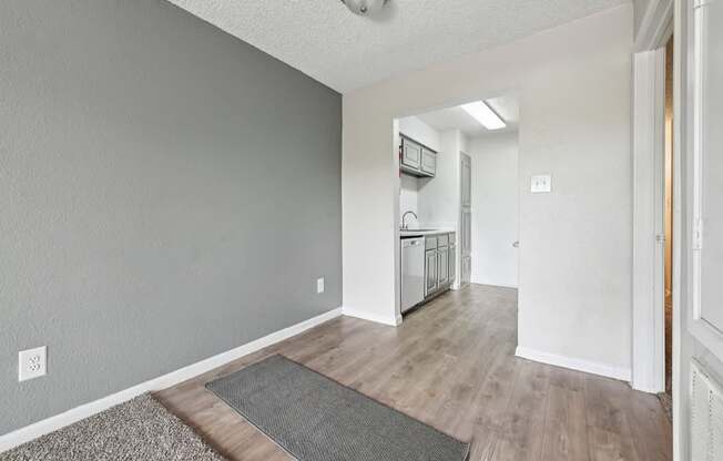 A room with a grey wall and a wooden floor.