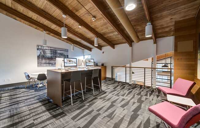 an office space with a desk and chairs and a bar with chairs at Ashford Belmar Apartments, Colorado, 80226