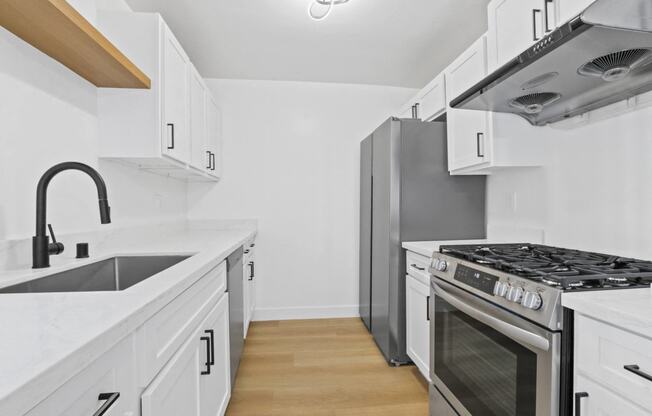 a kitchen with white cabinets and stainless steel appliances