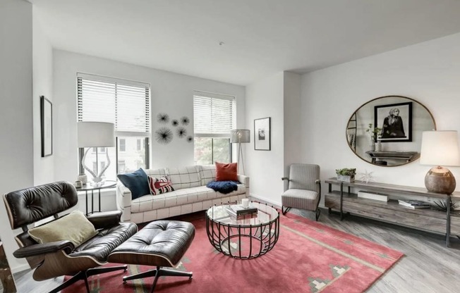 a living room filled with furniture and a large round mirror