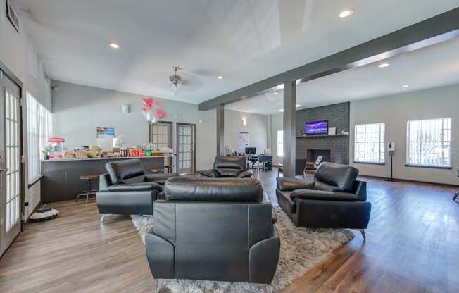 A living room with black leather furniture and a flat screen TV.