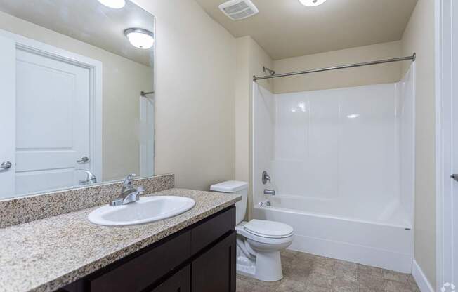 A bathroom with a sink, toilet, and bathtub.