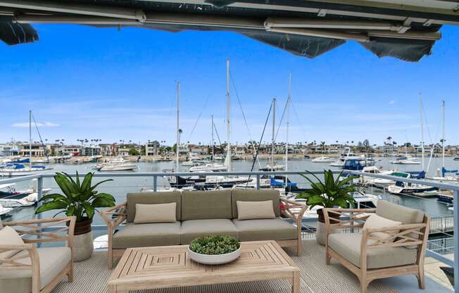 a patio with a couch and chairs overlooking a marina