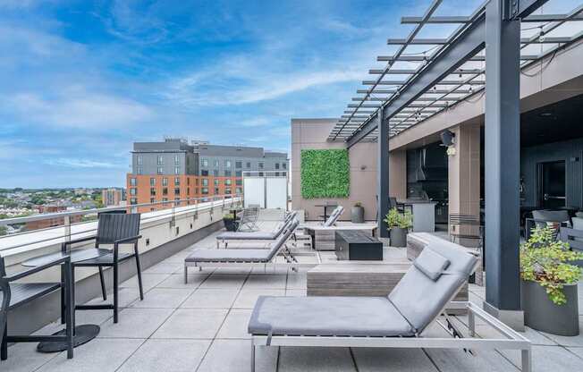 A rooftop patio with grey chairs and tables.