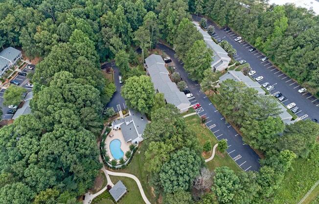 an overhead view of a park with a swimming pool and a parking lot