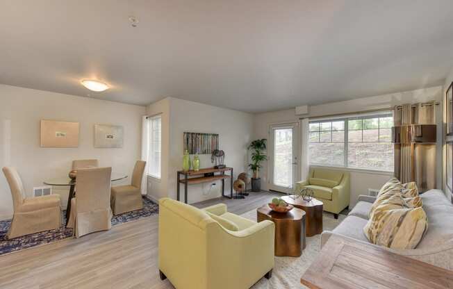 Dining Area with Wood Inspired Floor, Lime Green Chairs, Grey Sofas/ Chairs, Open View Windows, Brown Decorative Tables with Fruitbowl