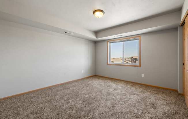 a bedroom with grey walls and carpet