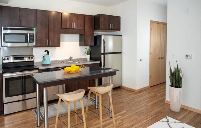 A modern kitchen with wooden cabinets and a black granite countertop.
