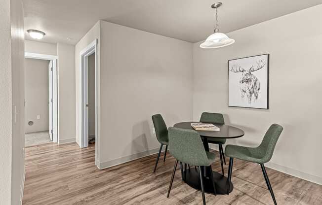 a dining room with a table and chairs and a door to a hallway