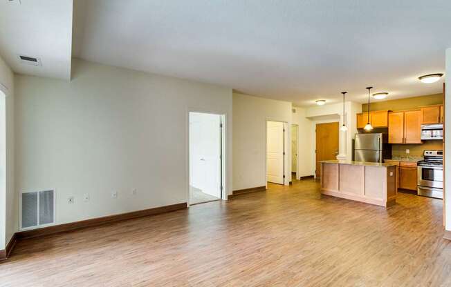 A kitchen area with a refrigerator, oven, and cabinets.
