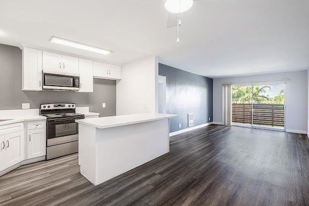A kitchen with white cabinets and a wooden floor.