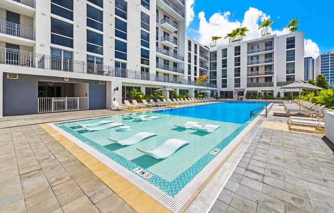 a large swimming pool in front of an apartment building