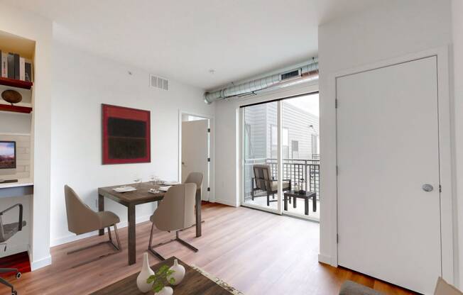 a dining room with a table and chairs and a sliding glass door to a balcony