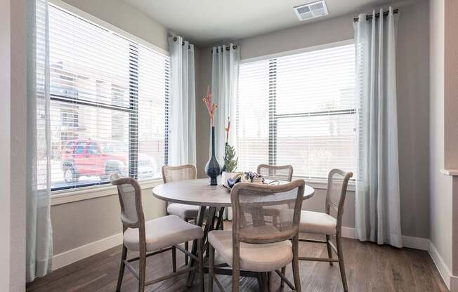 A dining room with a table and chairs.