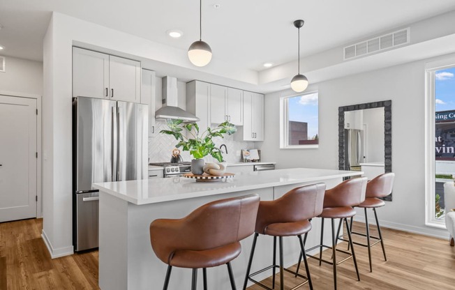a kitchen with a large island with bar stools