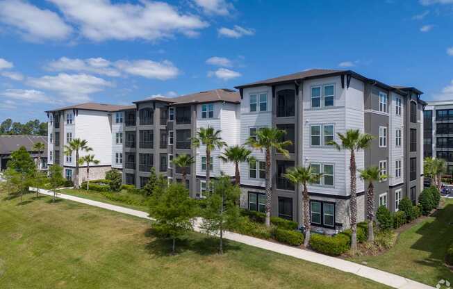 A large apartment complex with a green lawn in front.