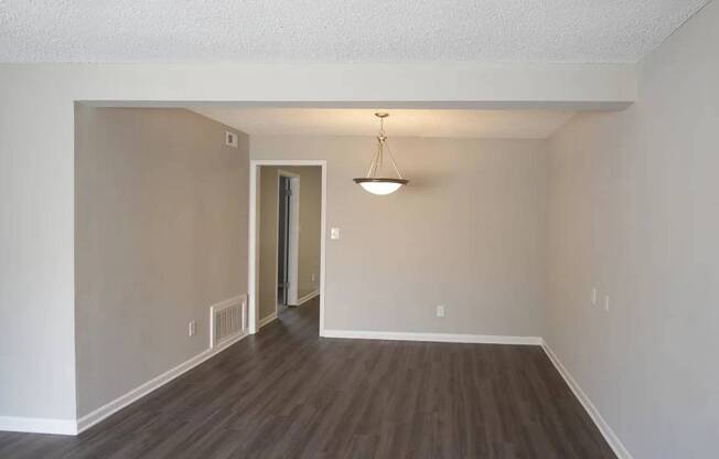 A room with a wooden floor and a light hanging from the ceiling.