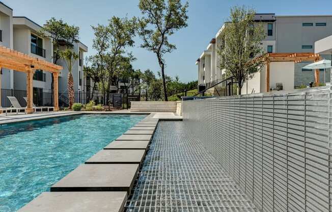 a swimming pool with buildings in the background