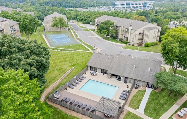 A large apartment complex with a pool and tennis court.