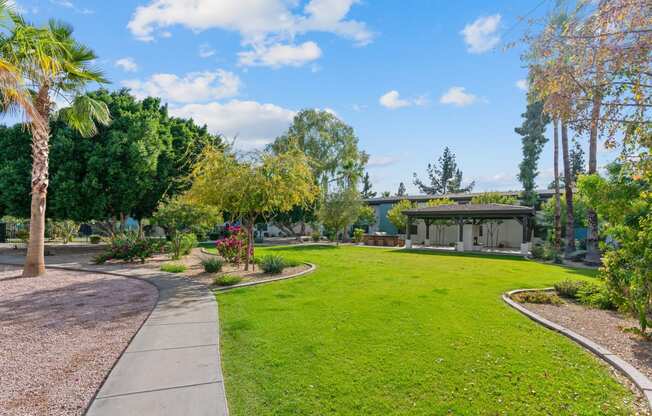 a garden with a lawn and a building in the background