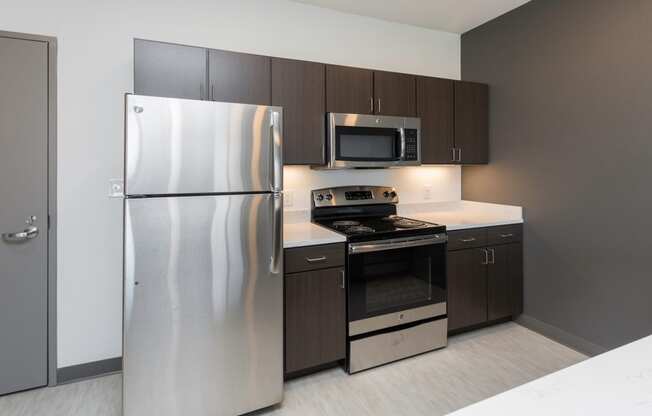 Modern open-concept kitchen and living area with stainless steel appliances.