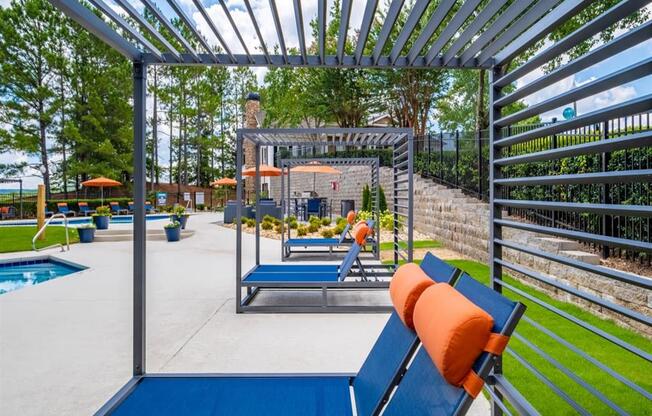 an outdoor lounge area with lounge chairs and a pool
