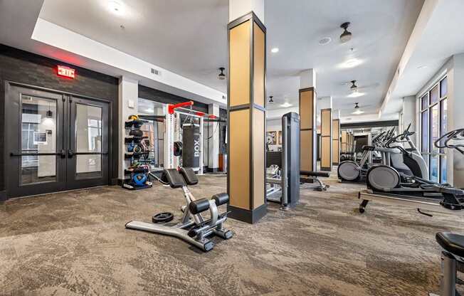 A gym with a variety of equipment including weights and cardio machines.